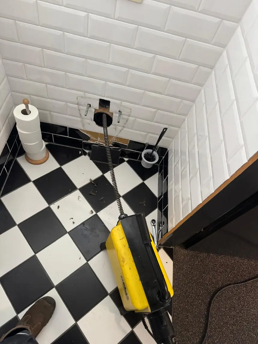 Loodgieter aan het werk bij een toilet
